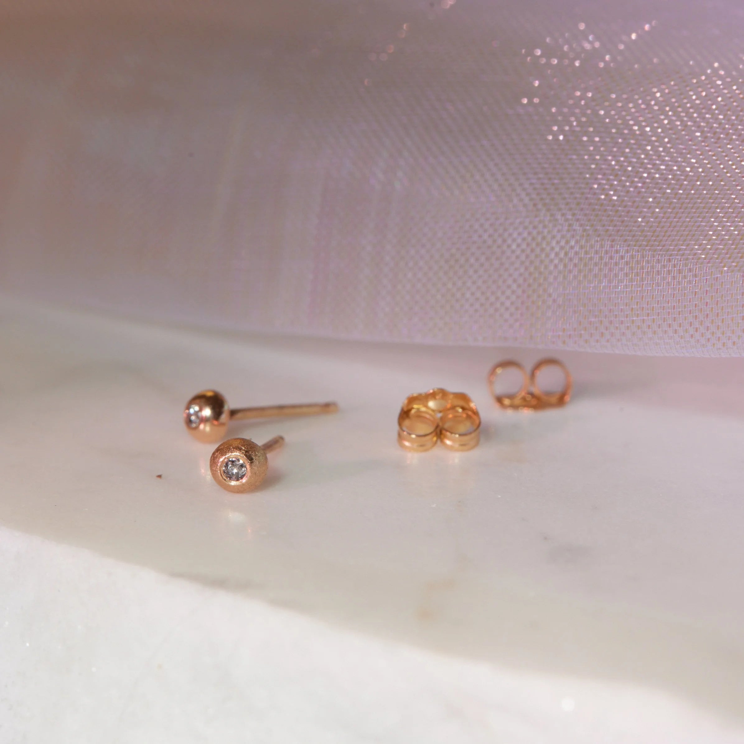 Set of gold earrings on a textured white surface