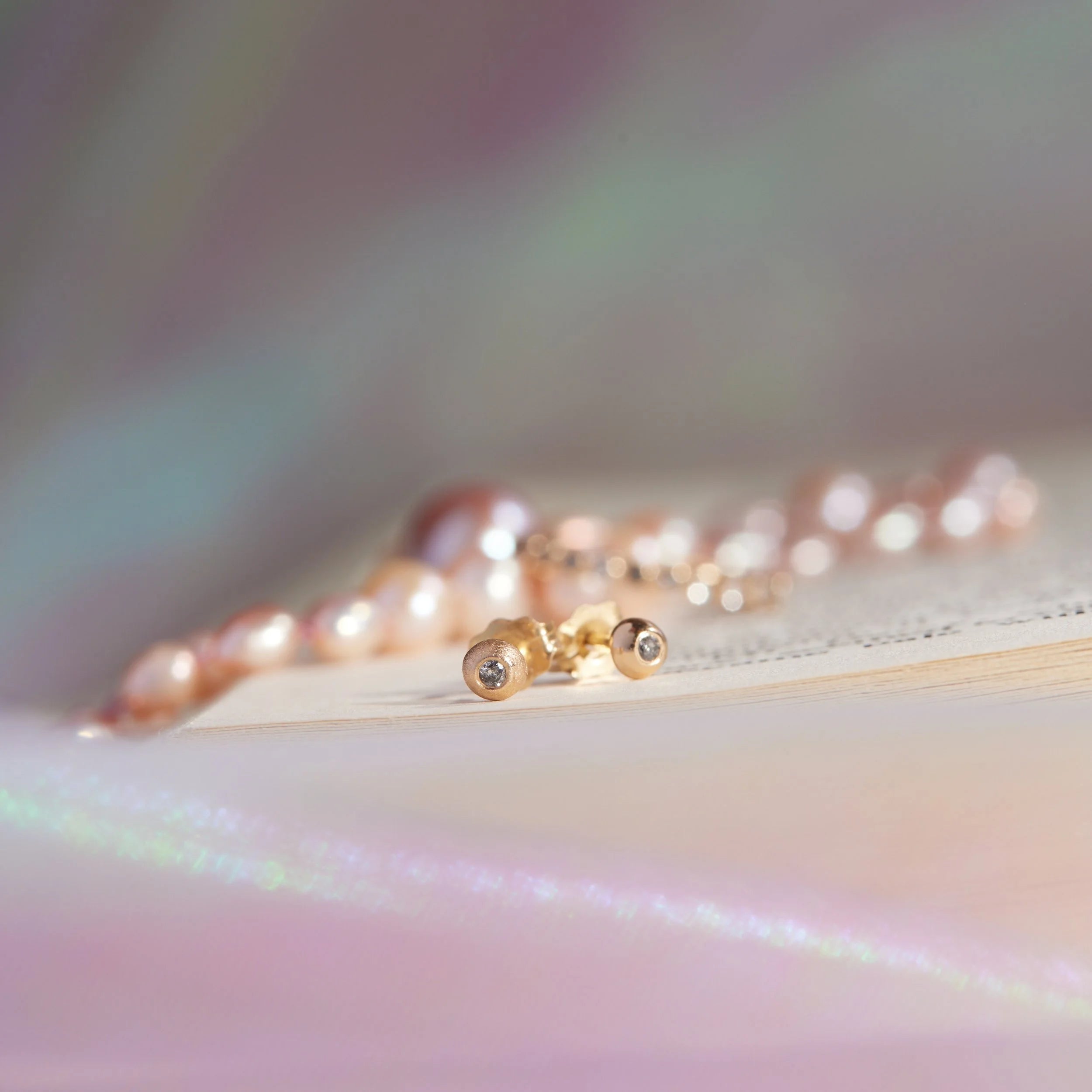 Pearl necklace on a reflective surface with a blurred background