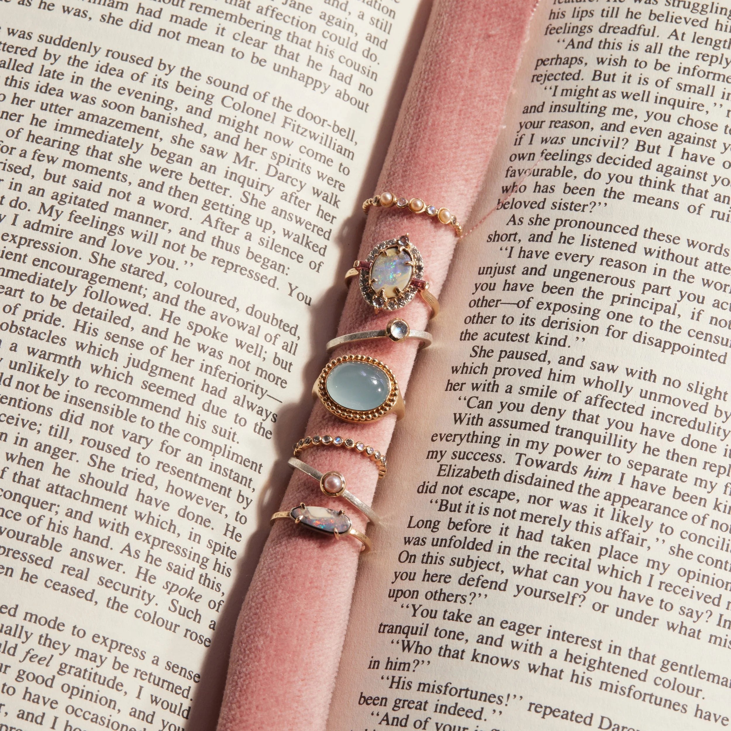 Pink ribbon with multiple rings on an open book