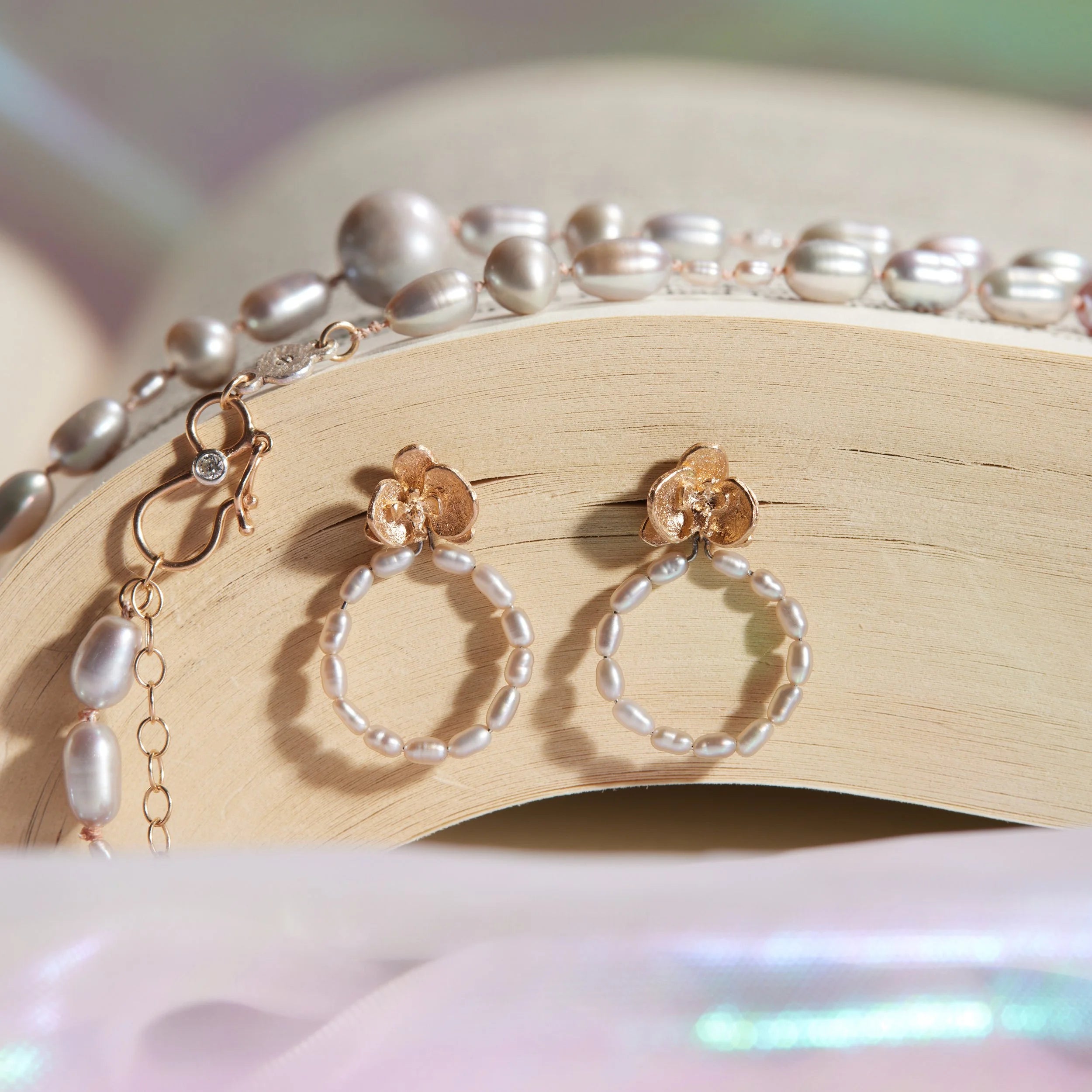 Pair of hoop earrings with pearl beads on a book