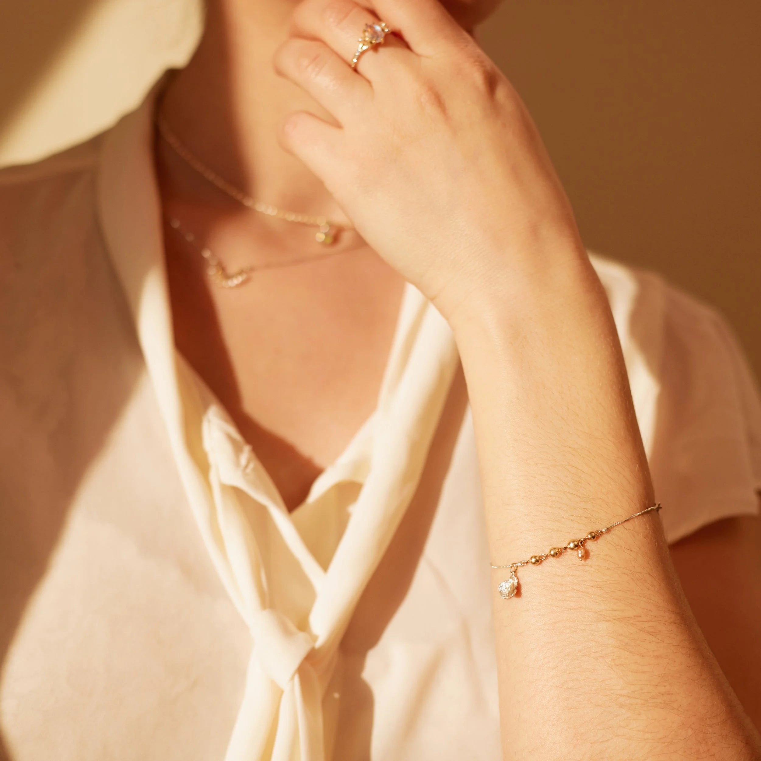 Close-up of a person wearing a bracelet and ring with a soft focus background