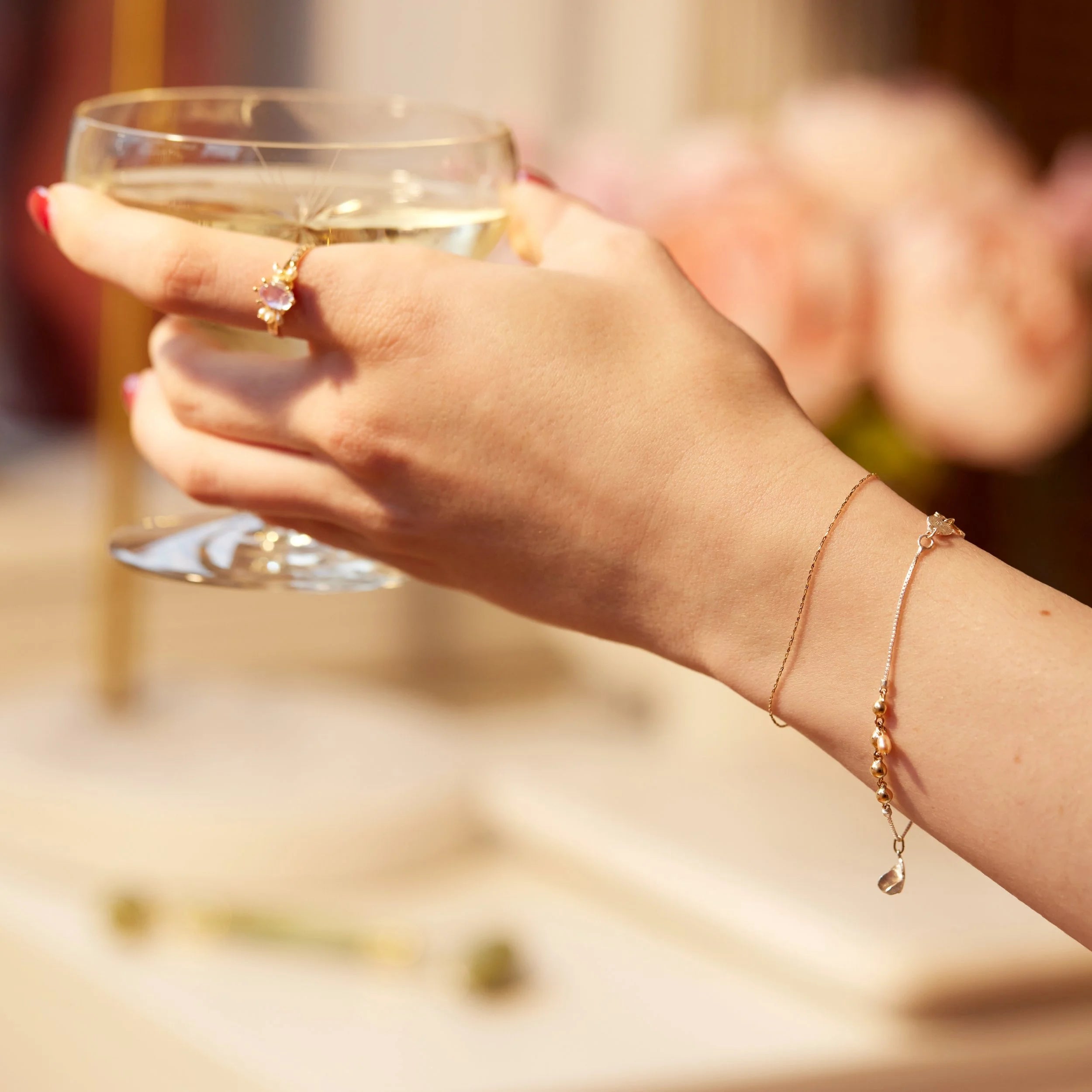 Hand holding a glass of champagne with a blurred background