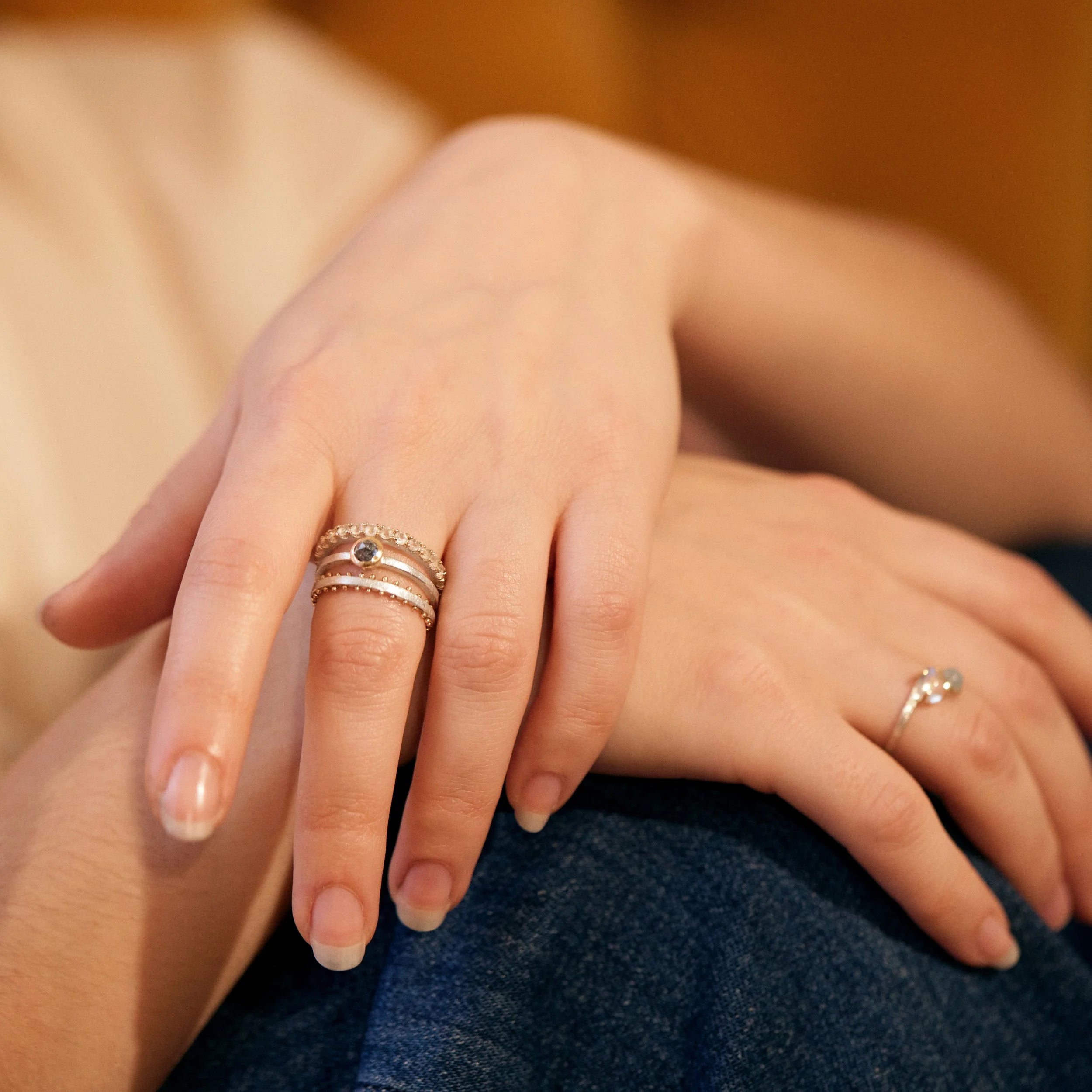 Close-up of hands with rings on fingers against a neutral background