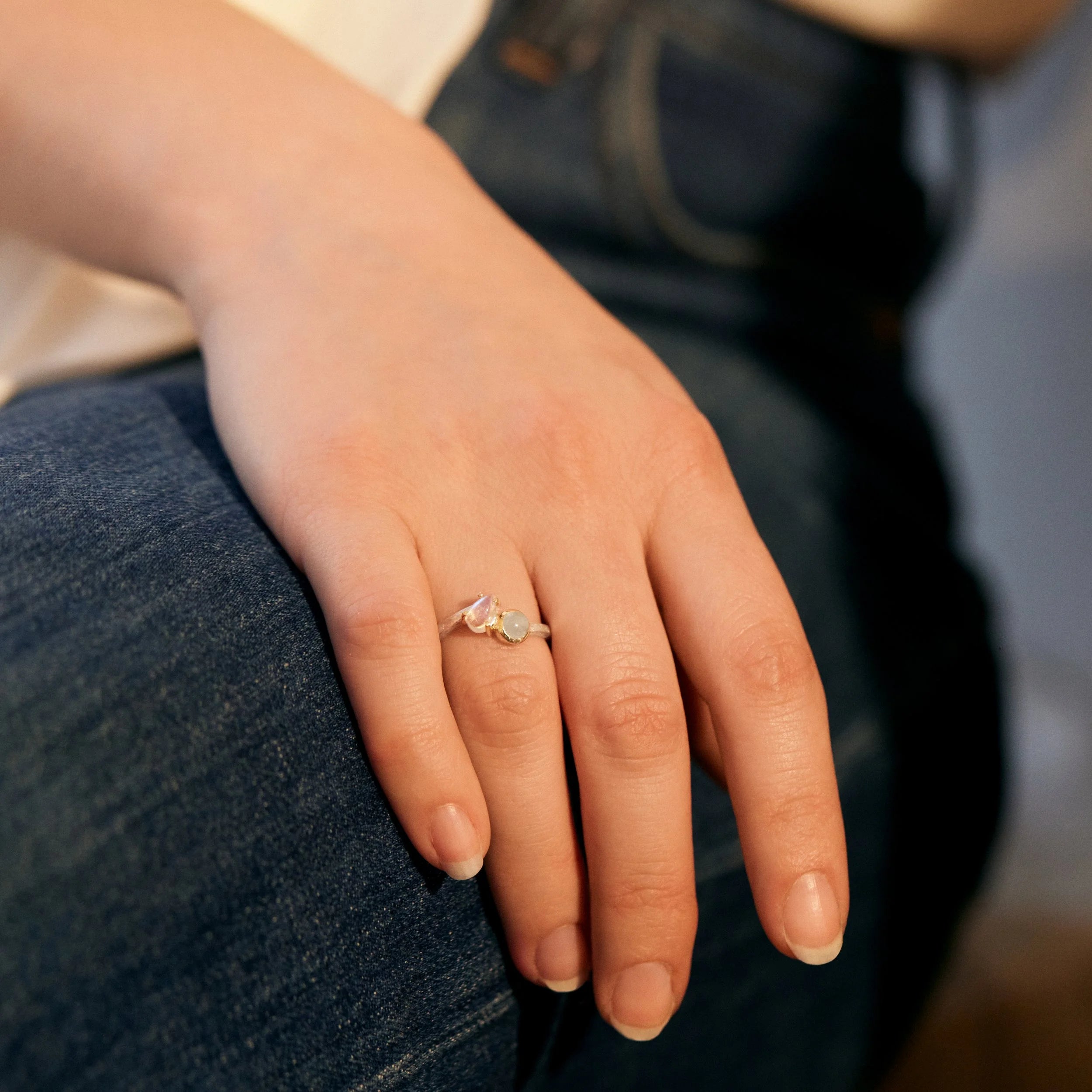 Hand wearing a ring with a blurred background