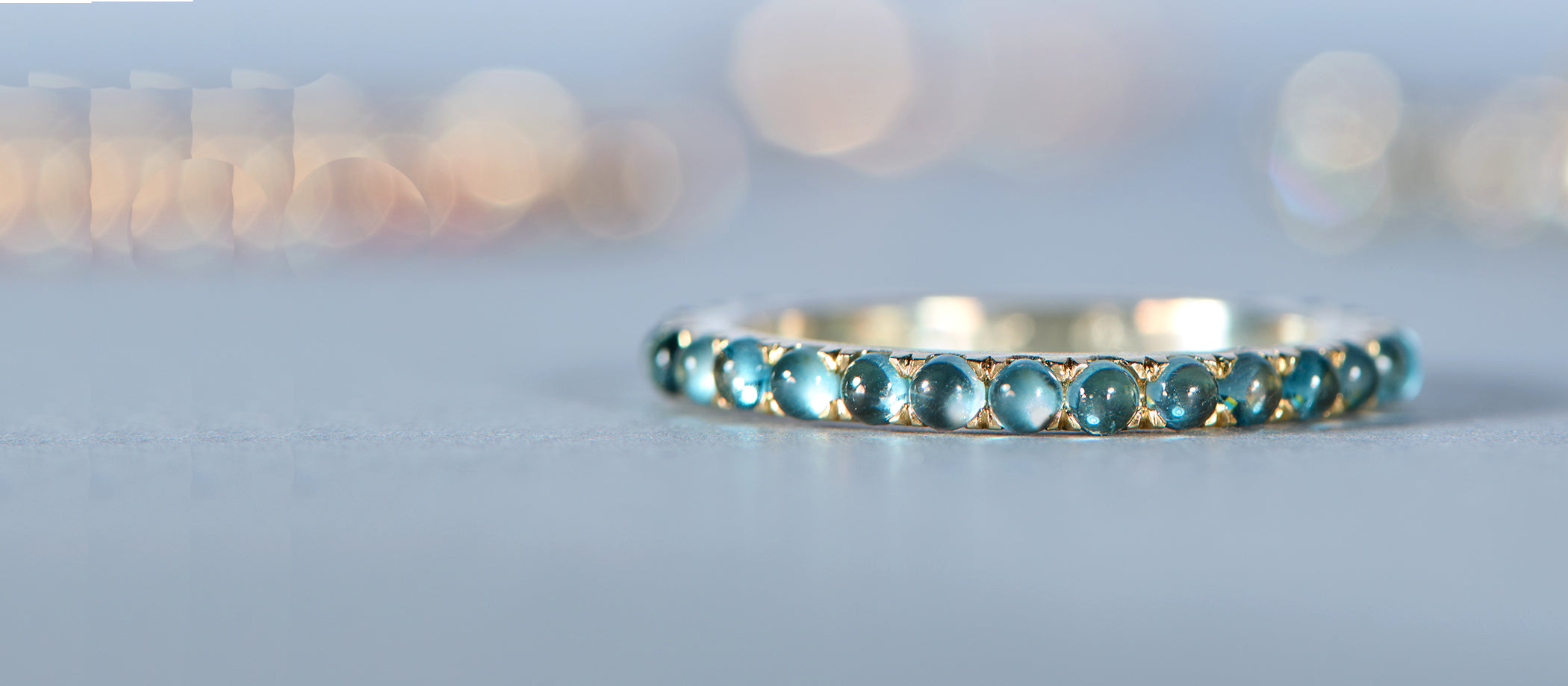 Gold ring with blue stones on grey background