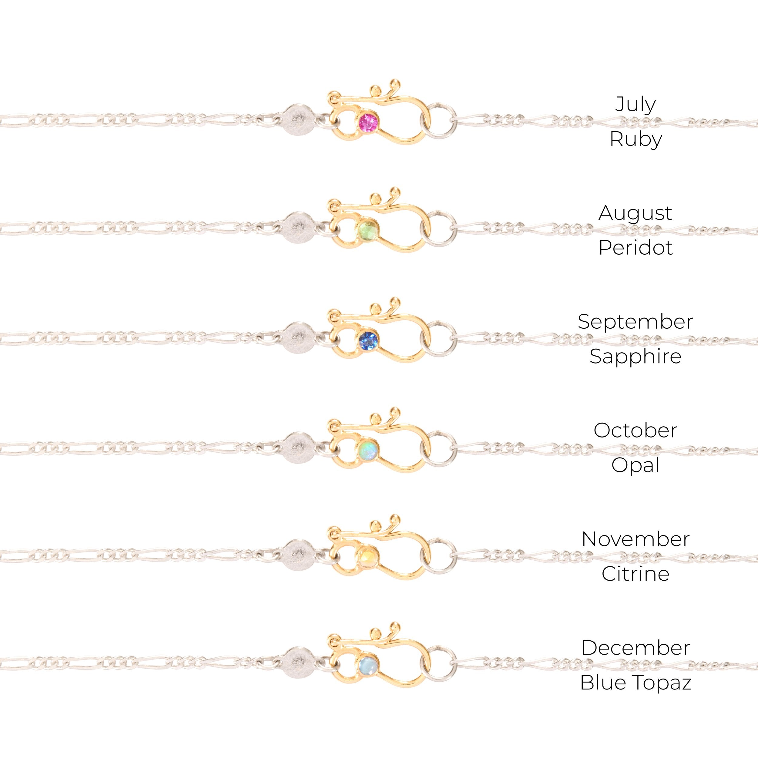 Gold necklaces set with gemstones for each month, on a white background.