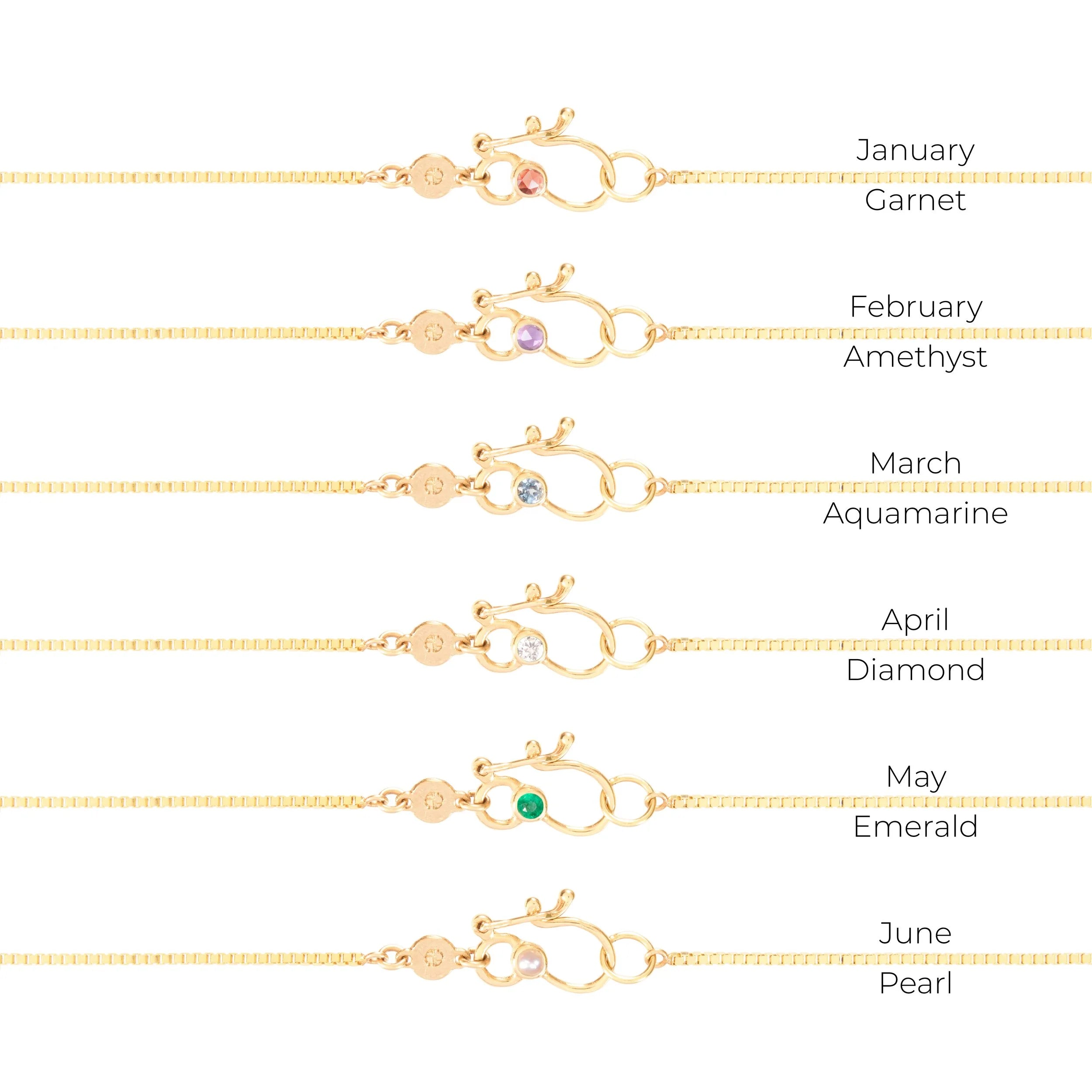 Gold necklaces with gemstones for each month, on a white background.