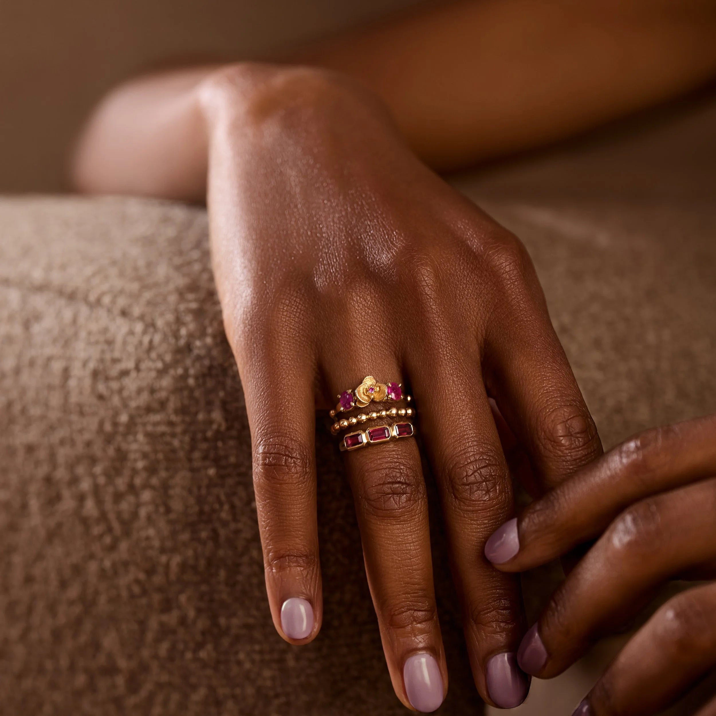 Hand with multiple rings on a textured surface