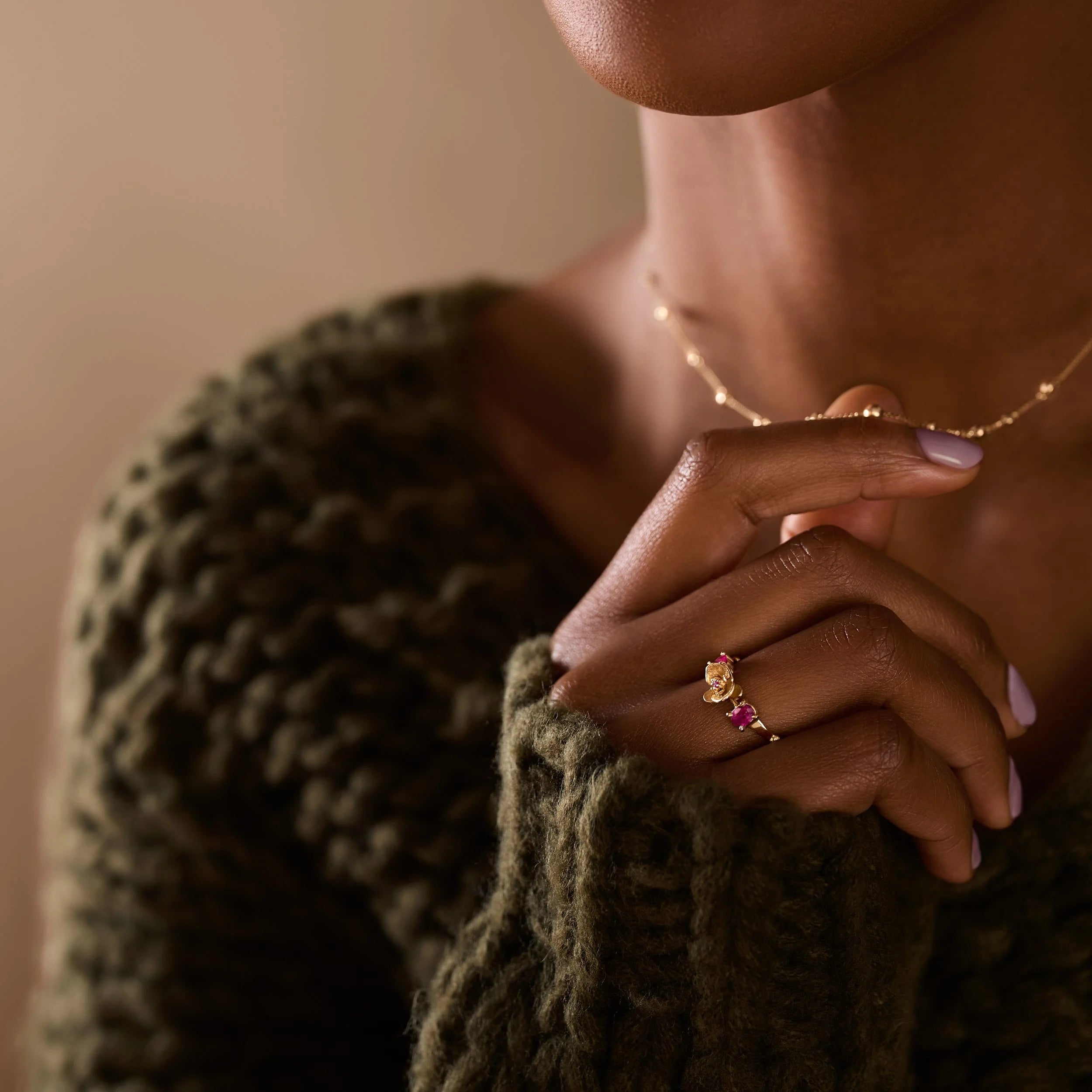 Person wearing a green knitted sweater with a blurred background