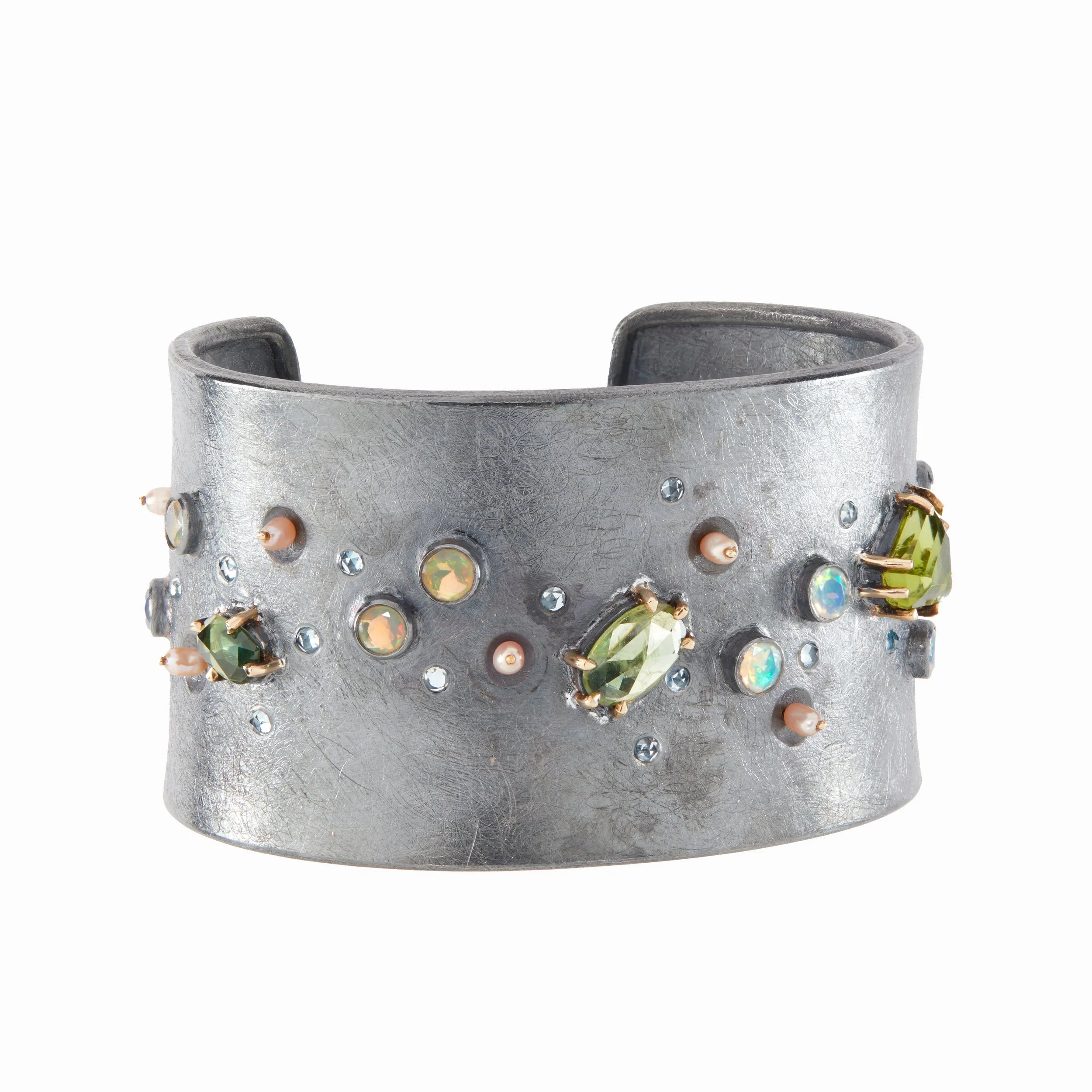Silver cuff bracelet with embedded gemstones on a white background