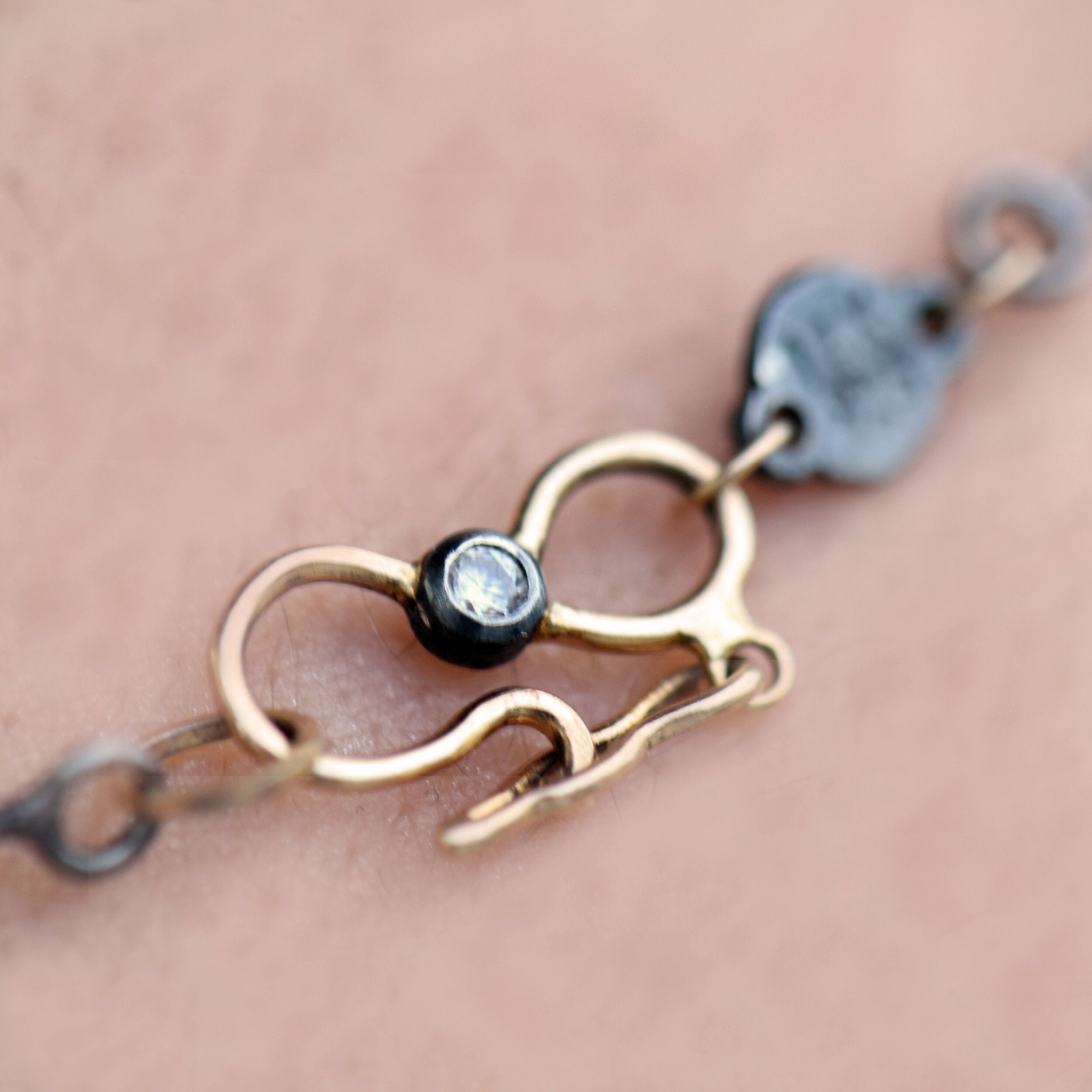 Necklace clasp with gold and silver design on a person's neck