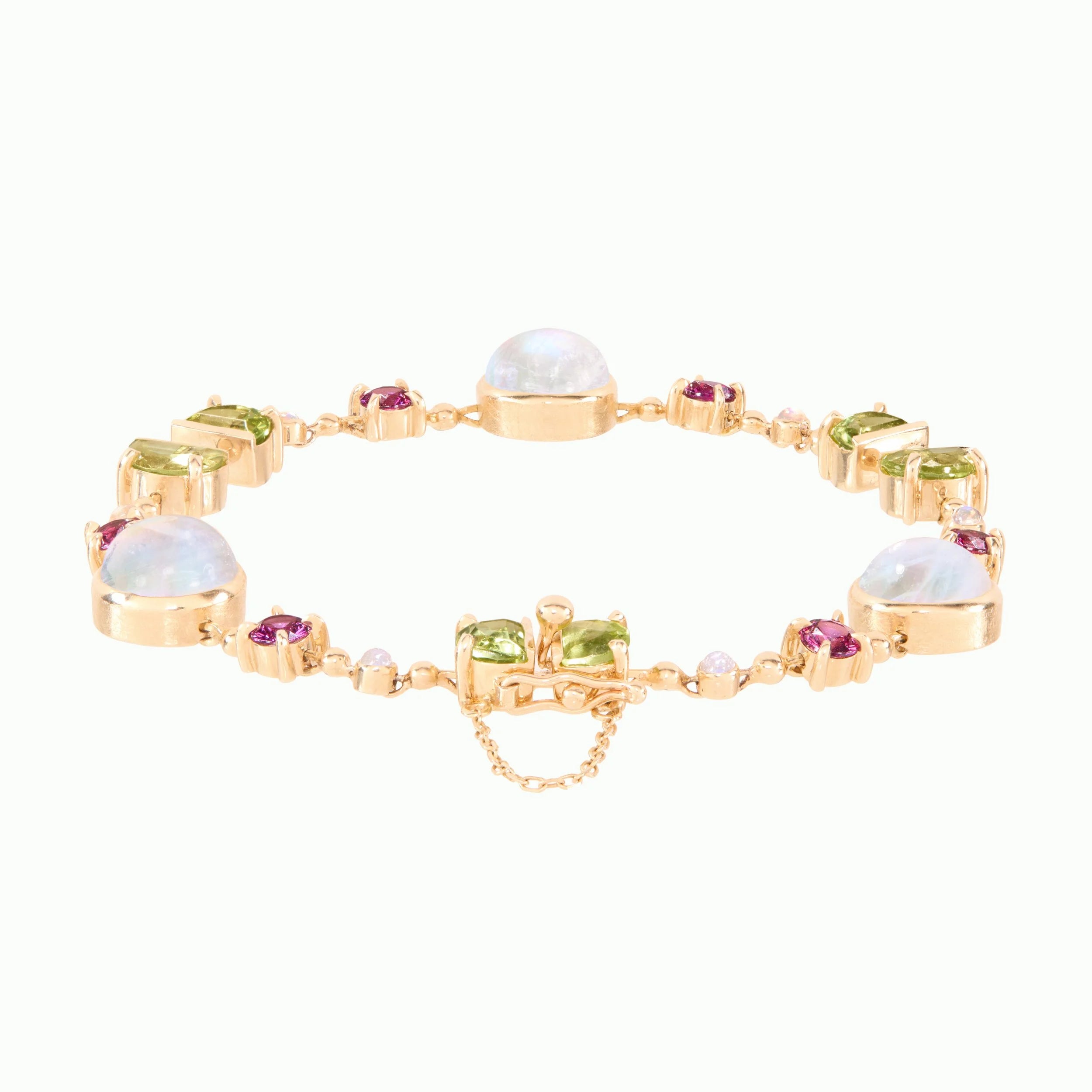 Gold bracelet with various gemstones on a white background