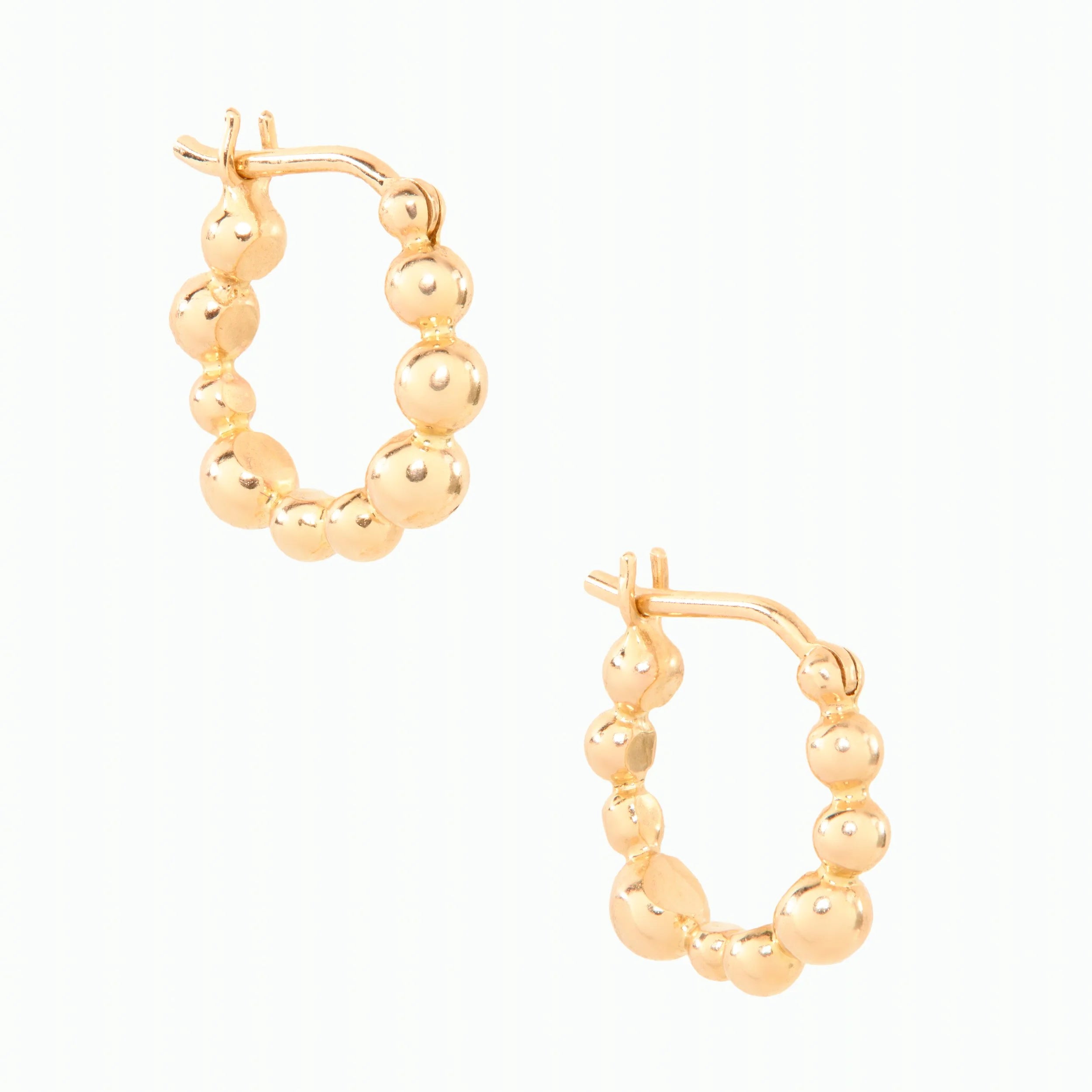 Gold hoop earrings with spherical beads on a white background