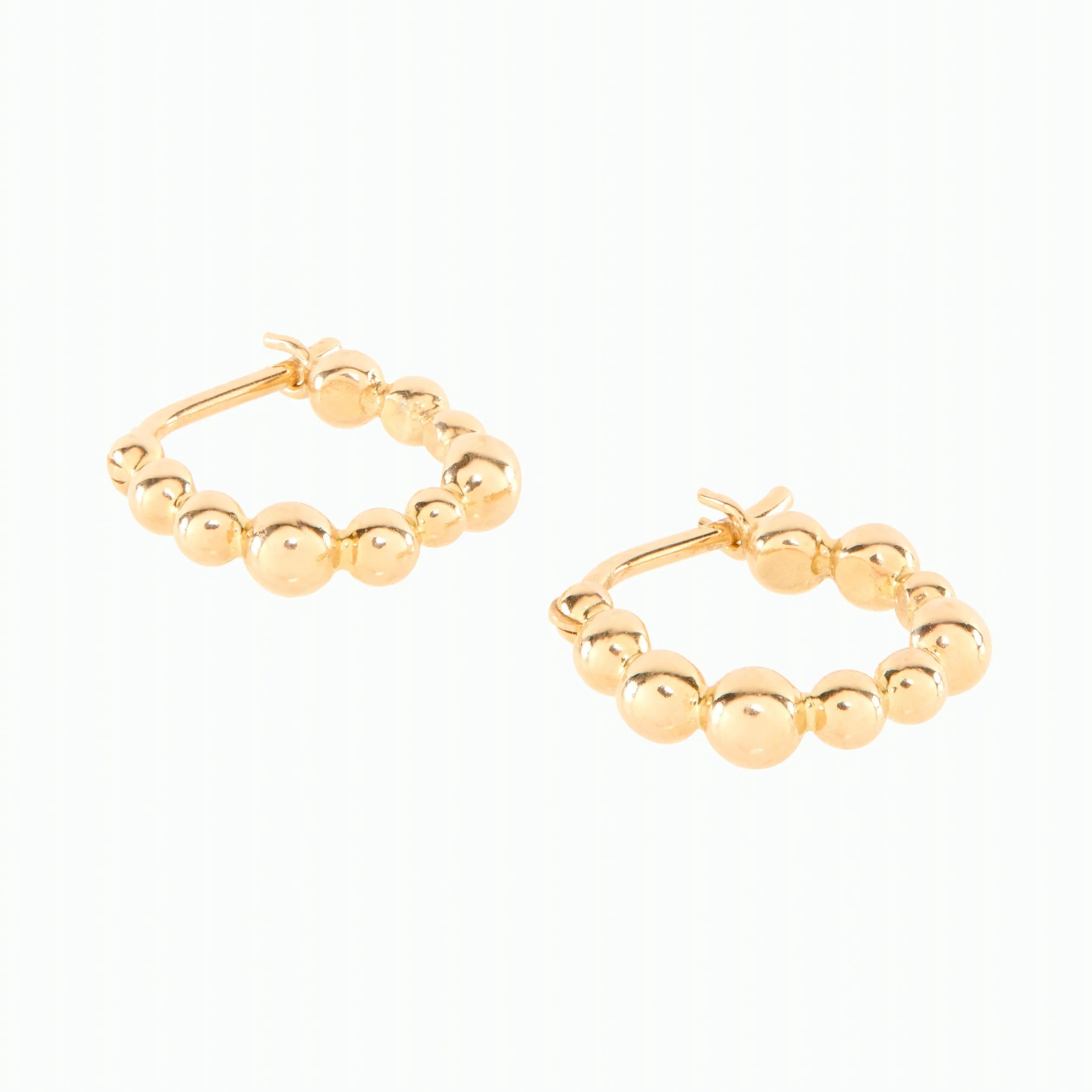 Gold hoop earrings with bead detailing on a white background