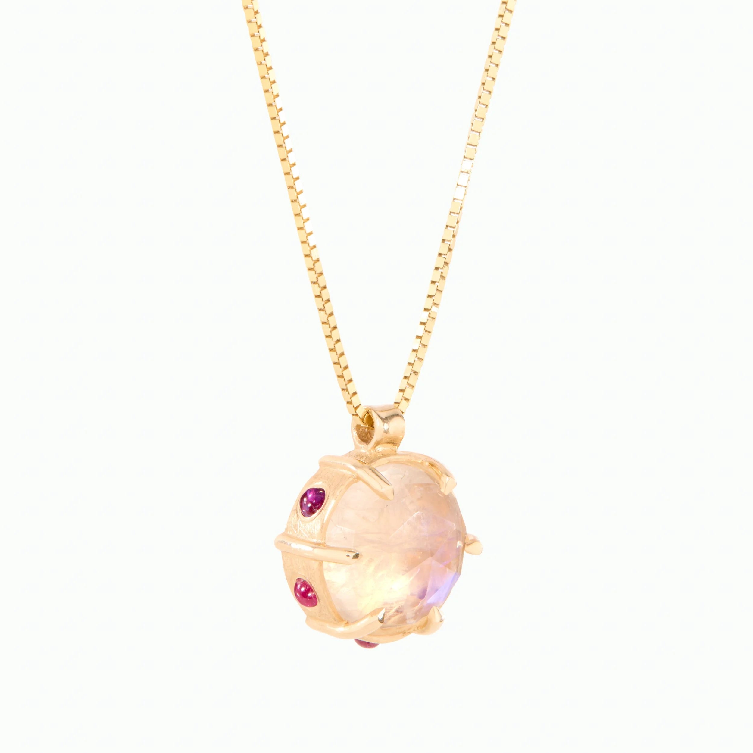 Gold necklace with a colorful moonstone on a white background