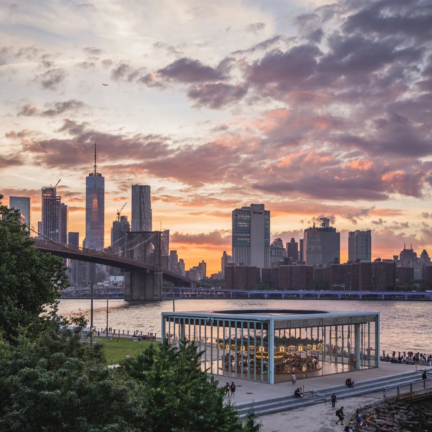 City skyline with a bridge and sunset, featuring the Brooklyn Bridge and Manhattan skyline.