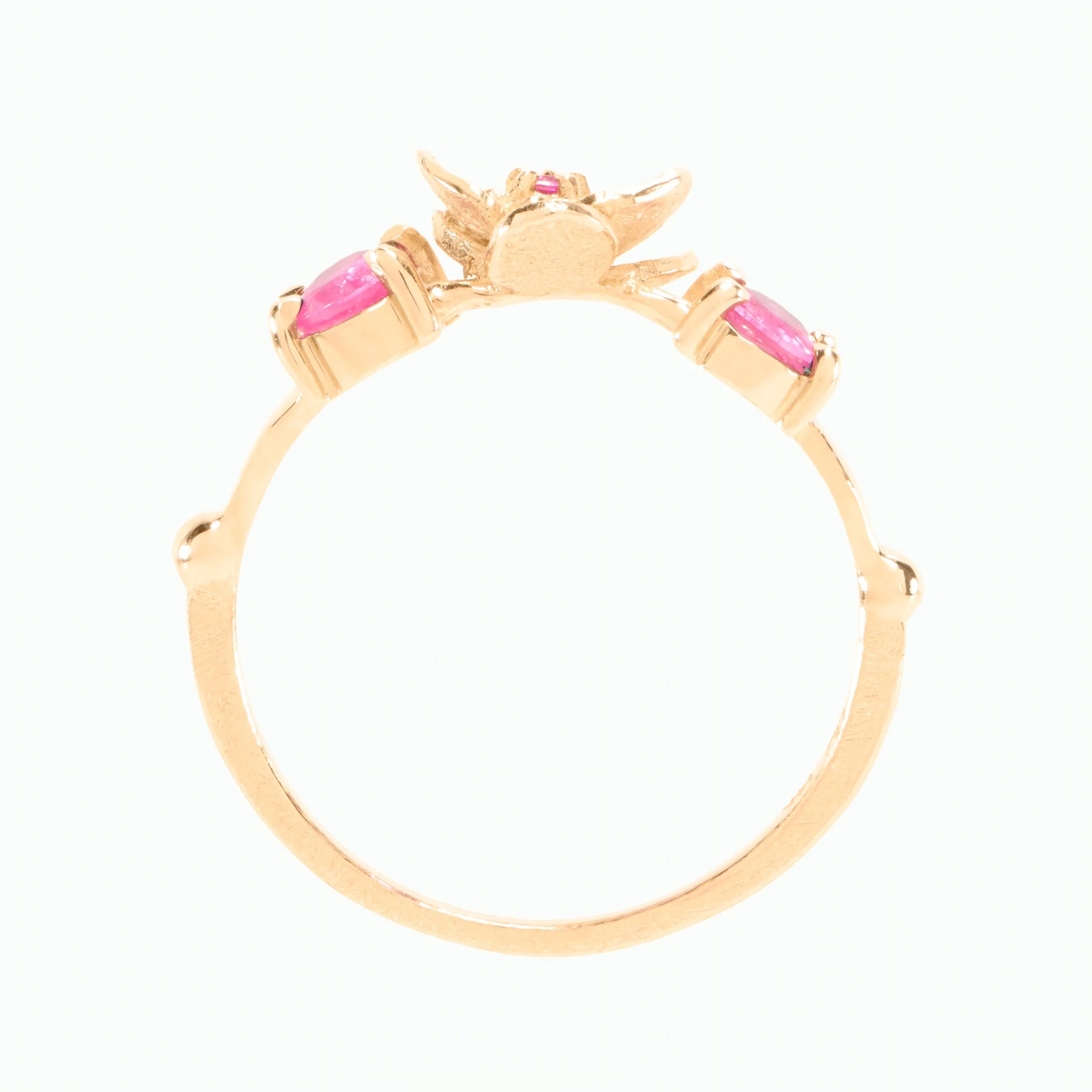 Gold ring with pink gemstones on a white background