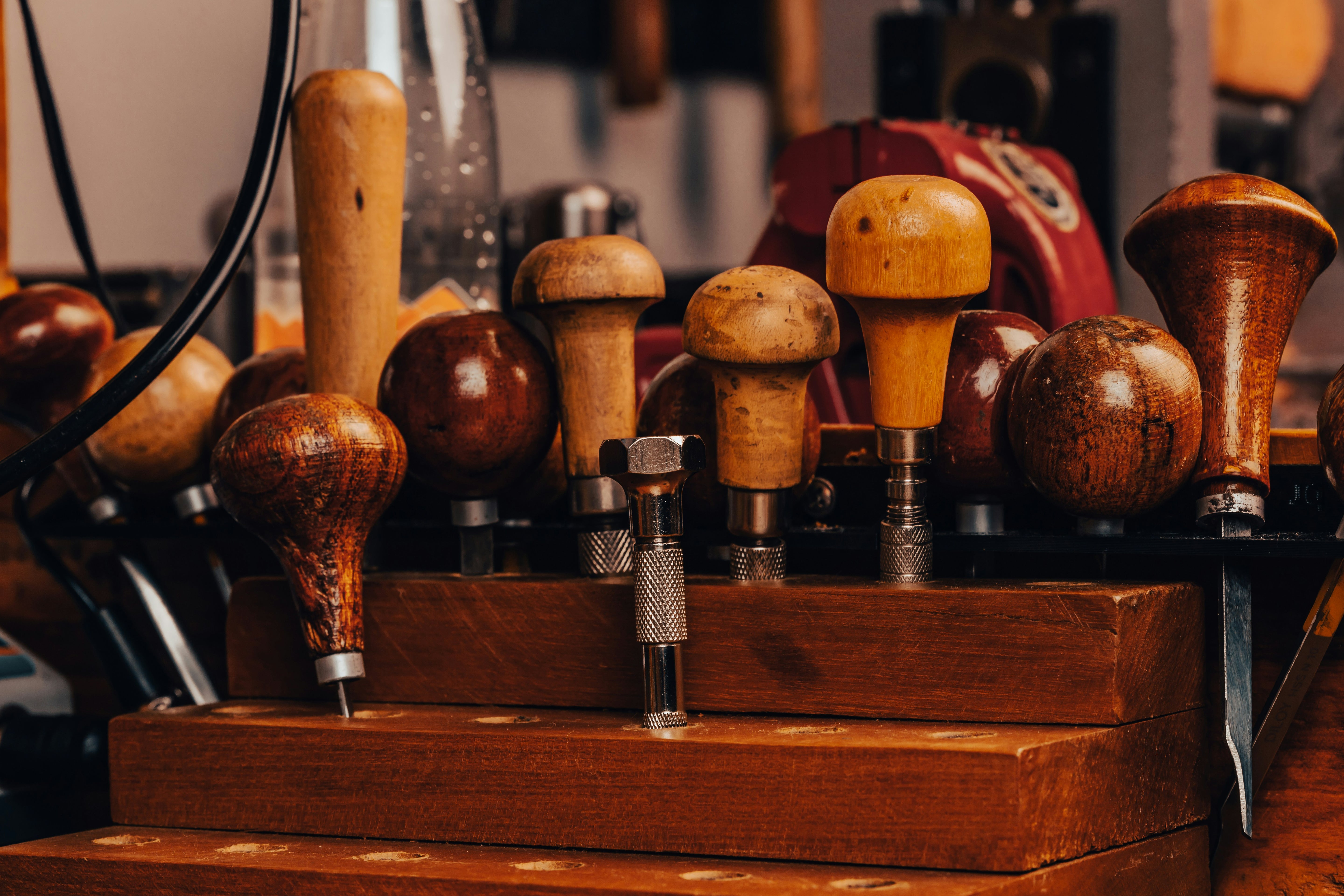 Collection of wooden and metal engraving tools on a wooden stand